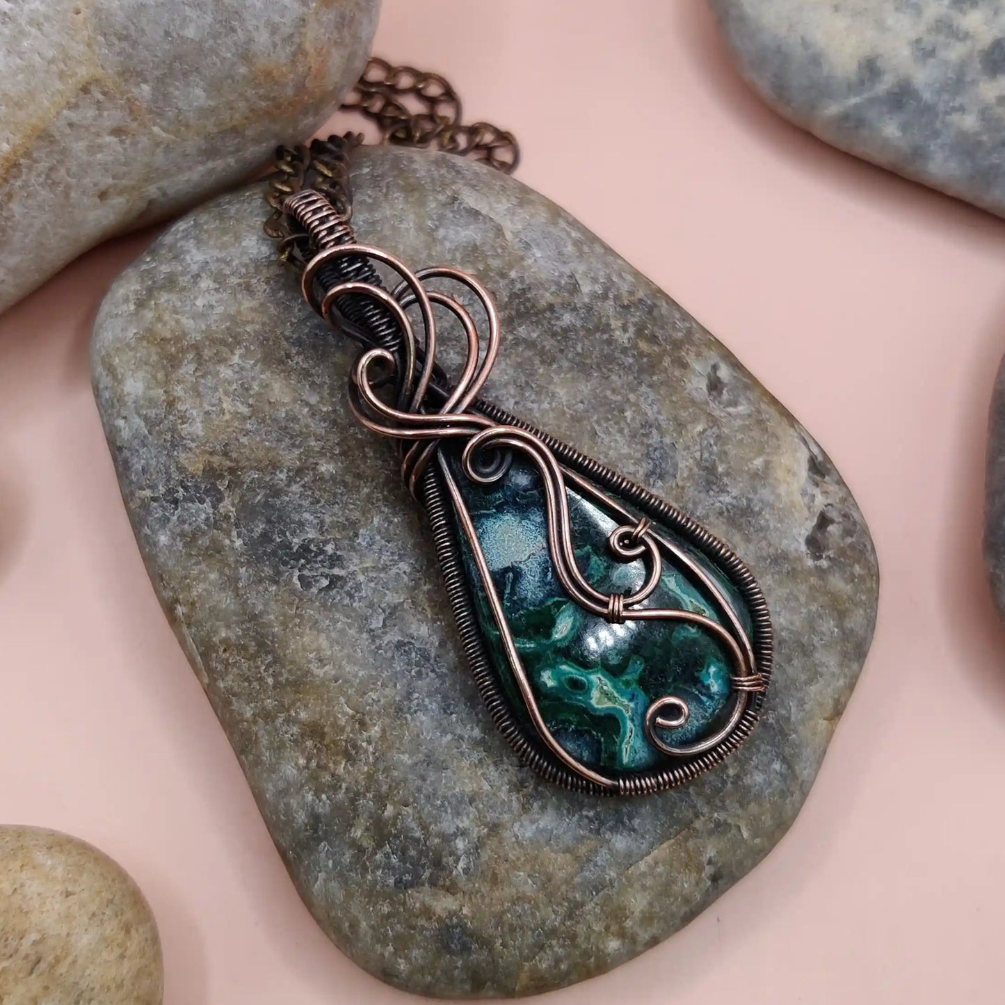 a naturally occurring rare mineral crystal combination of chrysocolla a blue coloured crystal and malachite a green coloured crystal in a copper pendant made by sanguine aura handcrafted jewellery