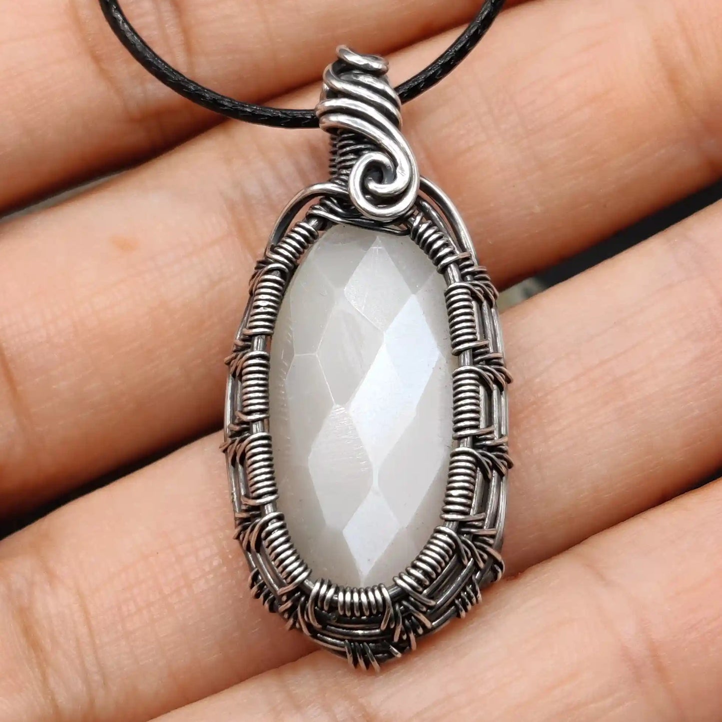 Kahaan white moonstone silver pendant made with heavy weaving patterns on the sides.