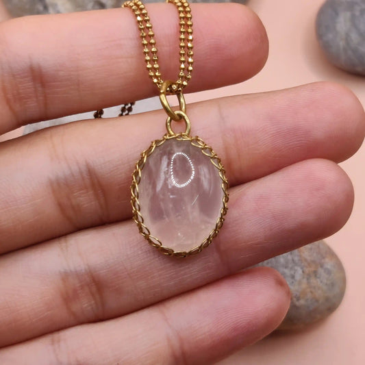 Meera rose quartz pendant in brass 005 held in hand, made in India with natural rose quartz and antibacterial brass.
