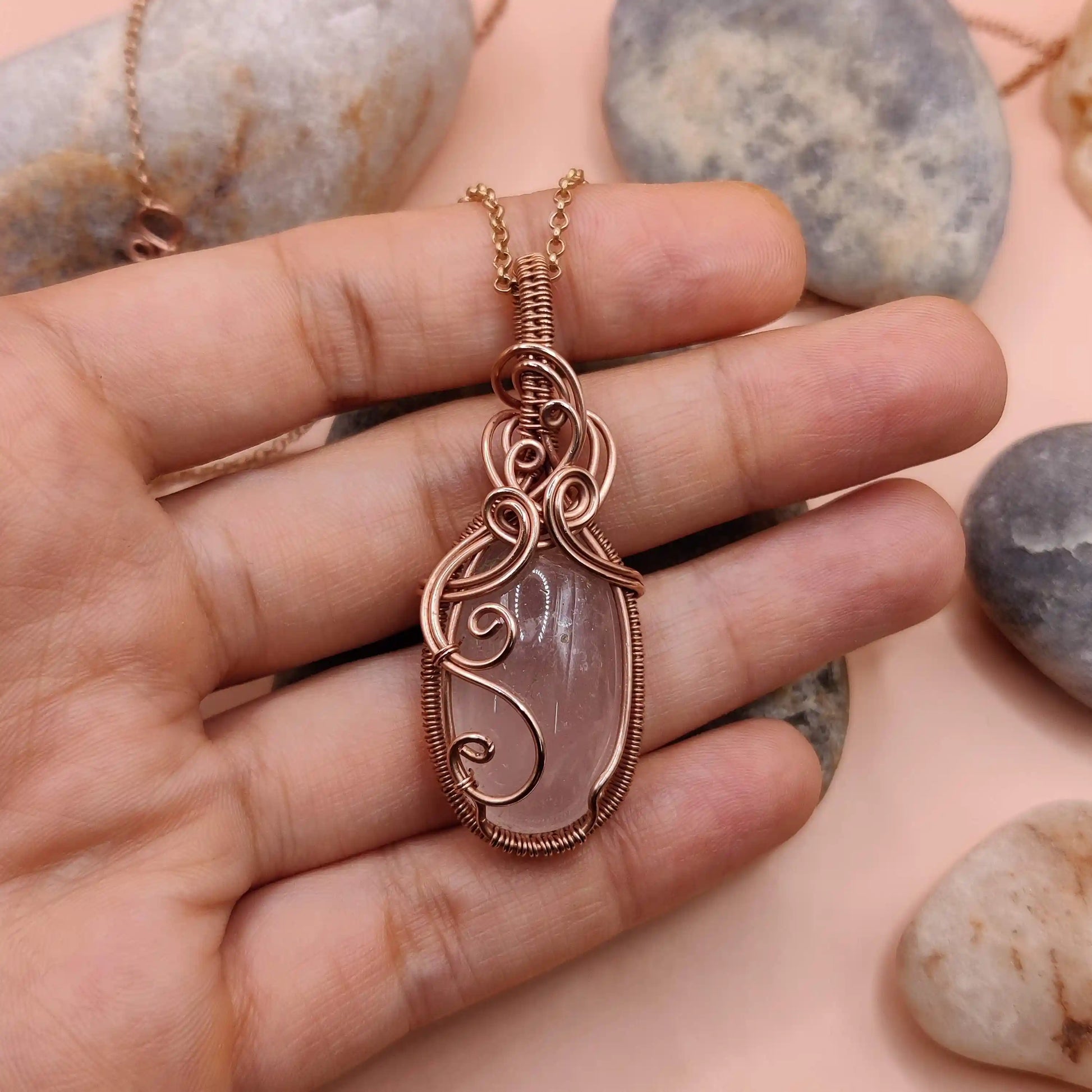 runi 007 rose quartz copper necklace in hand, made by sanguine aura handmade crystal jewellery